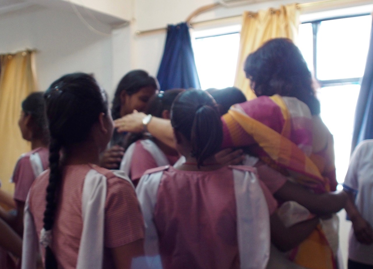 Prerna girls hugging Dr. Urvashi Sahni in a group