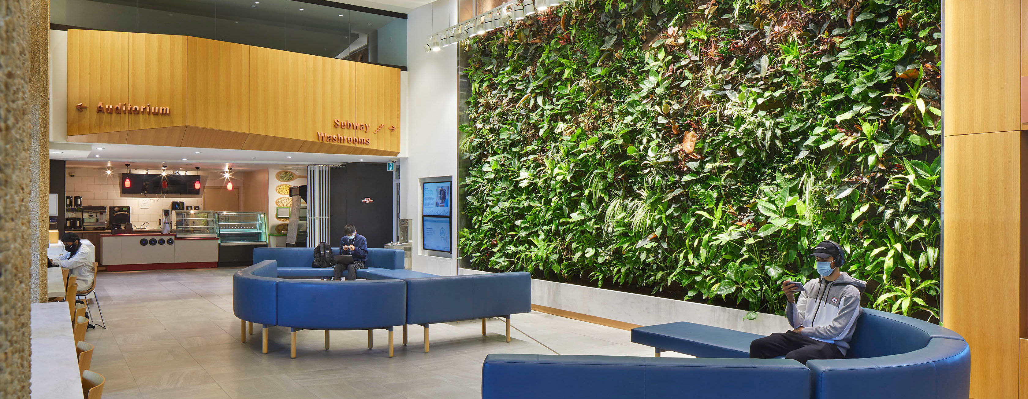 OISE Lobby with students seated and wearing face masks.