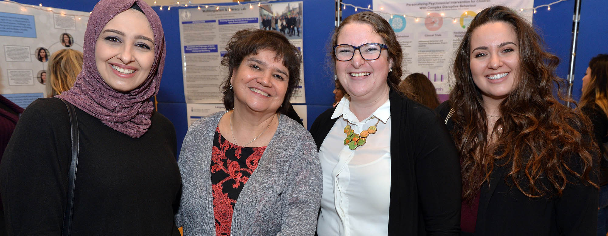 Four individuals attending an educational fair at the OISE building.