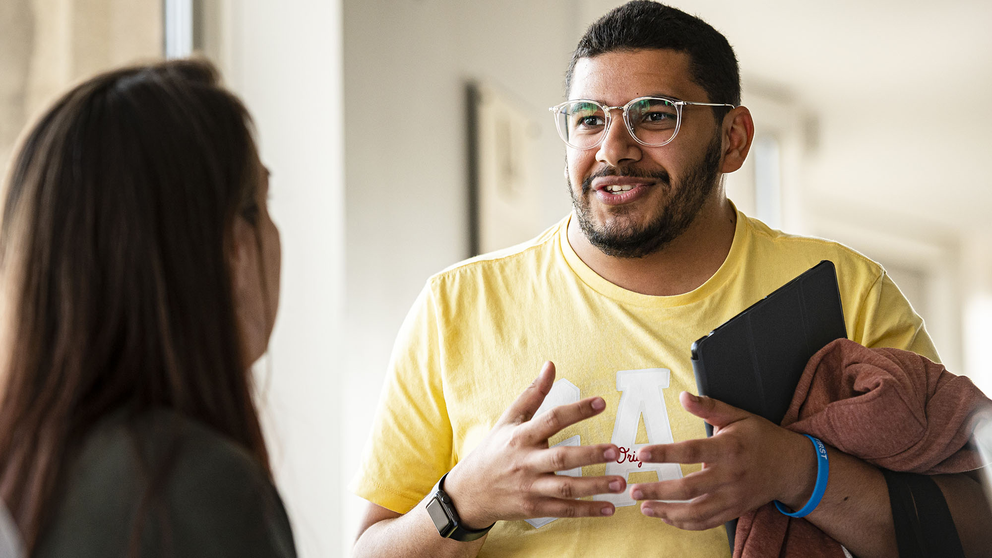 Two students talking in a hallway at OISE.