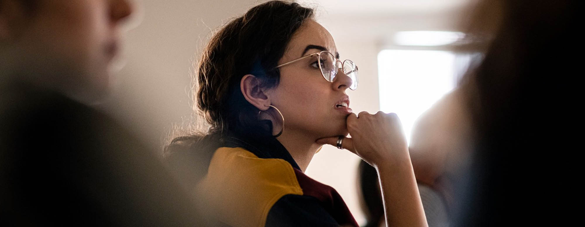 A student listening intently in a lecture hall. 