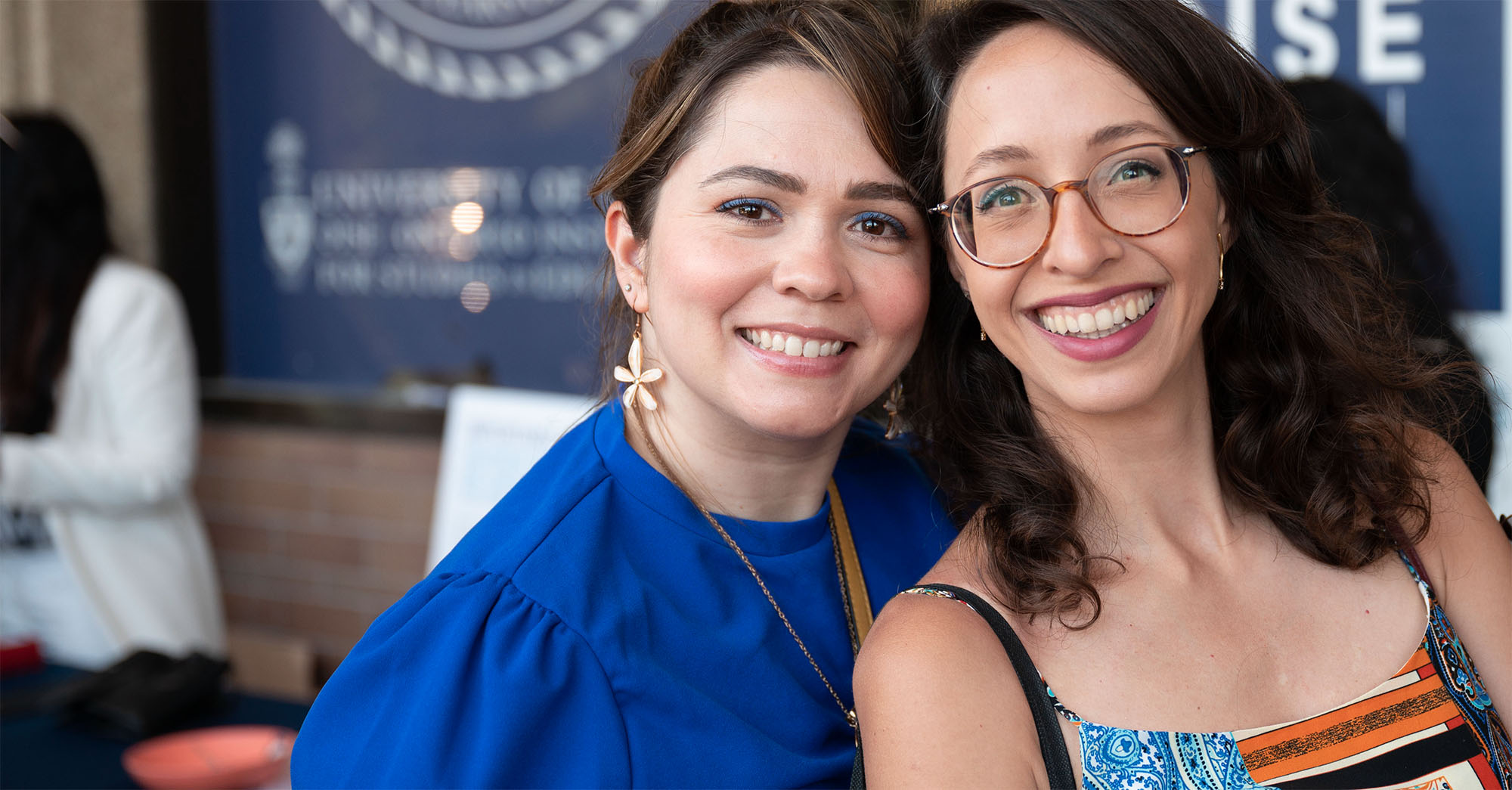 Two individuals smiling at OISE Swag Day. 