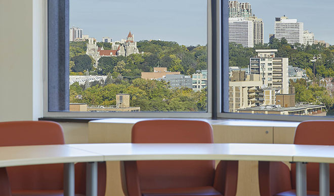 A classroom with a nice view of Toronto and orange chairs.