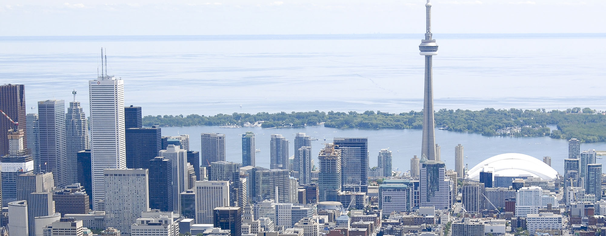 Toronto's cityscape. CN Tower and Lake Ontario in the background, buildings in the foreground.