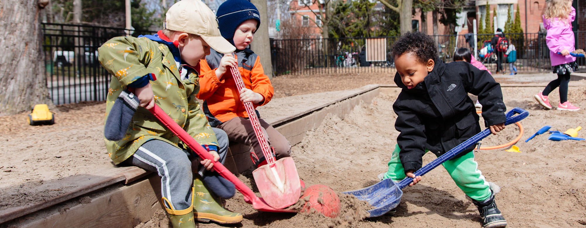 Three children playing in the JICS playground.