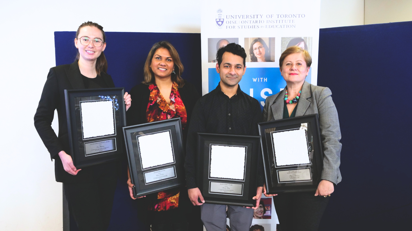 Four OISE staff members holding their awards