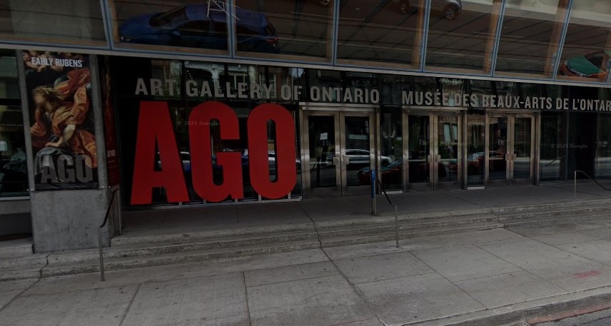  urban street and glass doors at front of building with large sign with letters A G O 