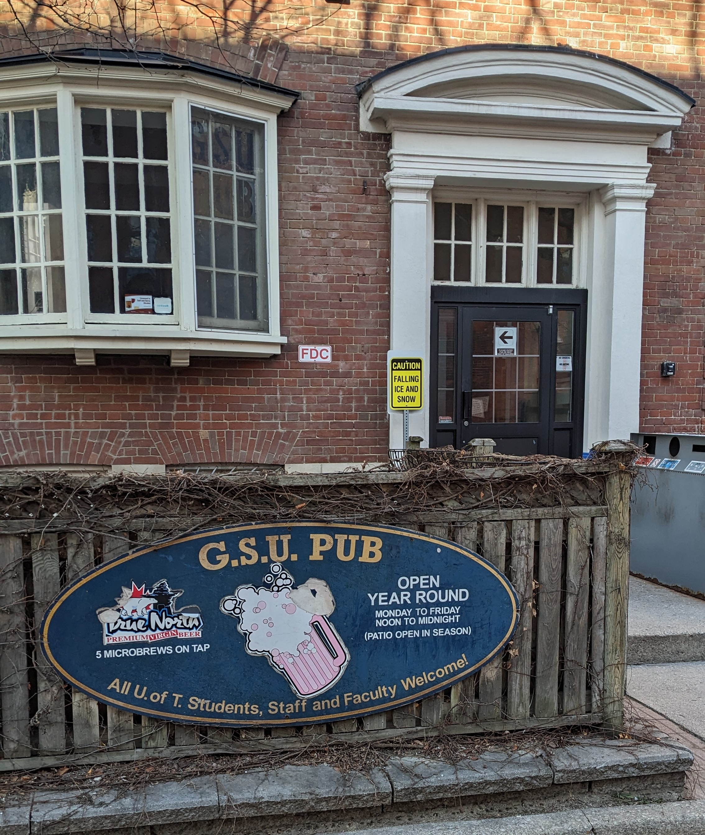 exterior of a brick building with an entrance door and a sign 