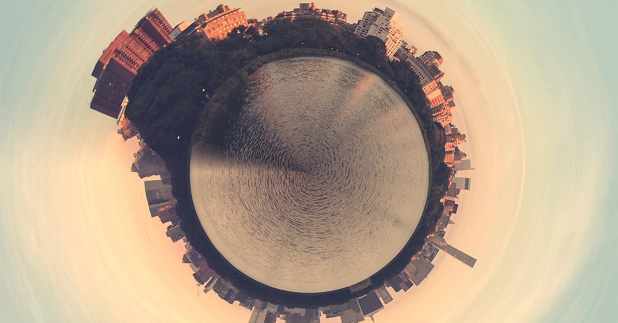 A 360 degree photo of a cityscape with water. The water appears in a circle in the middle of the photo.