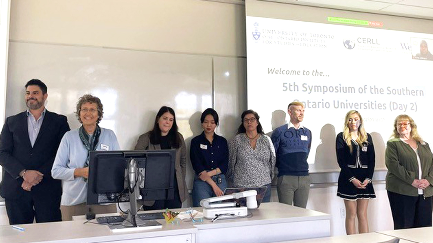 The symposium organizing committee standing at the front of a classroom