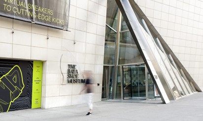 Glass entry door to concrete building with blurred image of human standing in front