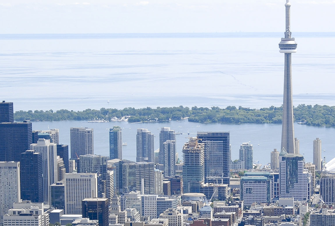 Toronto's cityscape. CN Tower and Lake Ontario in the background, buildings in the foreground.