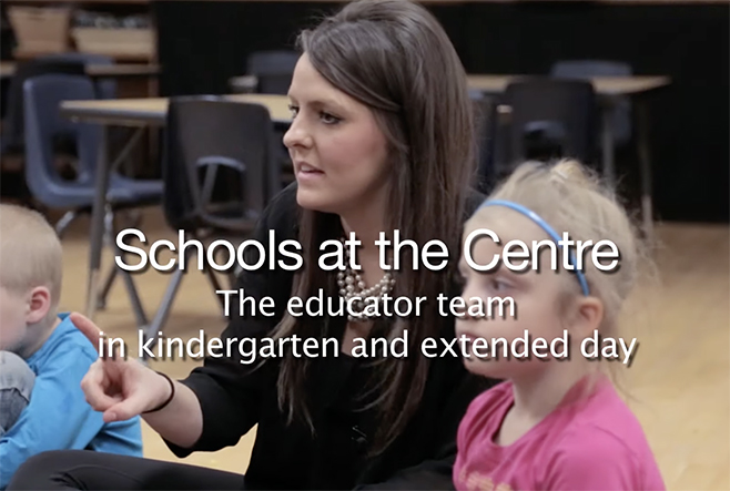 An educator sitting on the floor of a classroom with students. Text overlay says, "Schools at the Centre, The educator team in kindergarten and extended day"