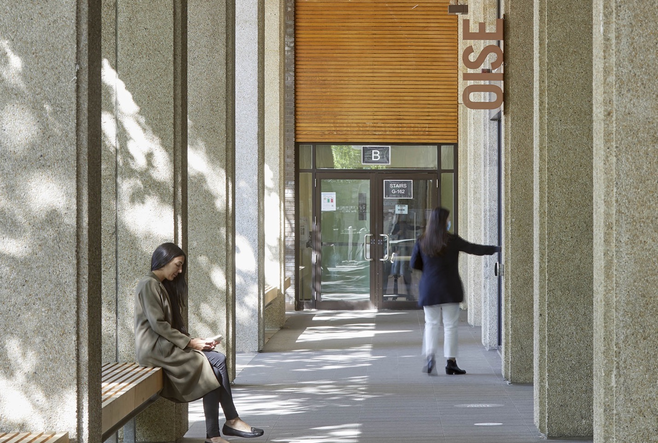 two female students in OISE walkway entrance