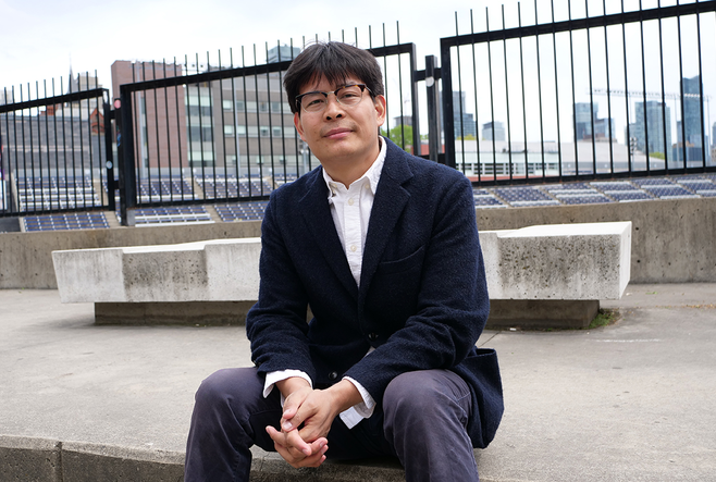 Nan La, a tibetan student presenting as a man, is sitting in front varsity stadium at the University of Toronto