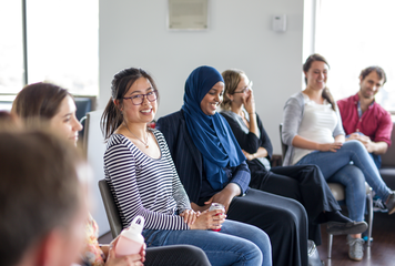 Group of 6 students sitting together in a row