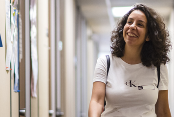 A student walking through an OISE hallway.