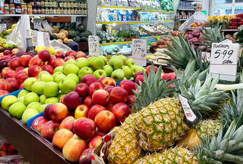 Fruits and vegetables arranged on tables and in bins