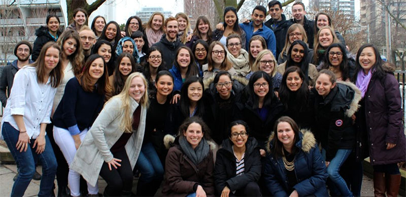 A group photo of ICS OISE alumni. Most students are wearing a winter coat.