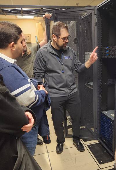 Server room demonstration led by OISE Education Commons' Associate Director of Digital Products & System Architecture, Bernie Spudic. Bernie is pointing toward a server cabinet with Full Stack Developer Bahman Yaghoobi looking on.