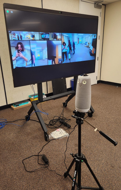 The Meeting Owl Pro being displayed, with OISE Education Commons' Communication Coordinator, Nathan Christie, shown in the accompanying TV monitor.