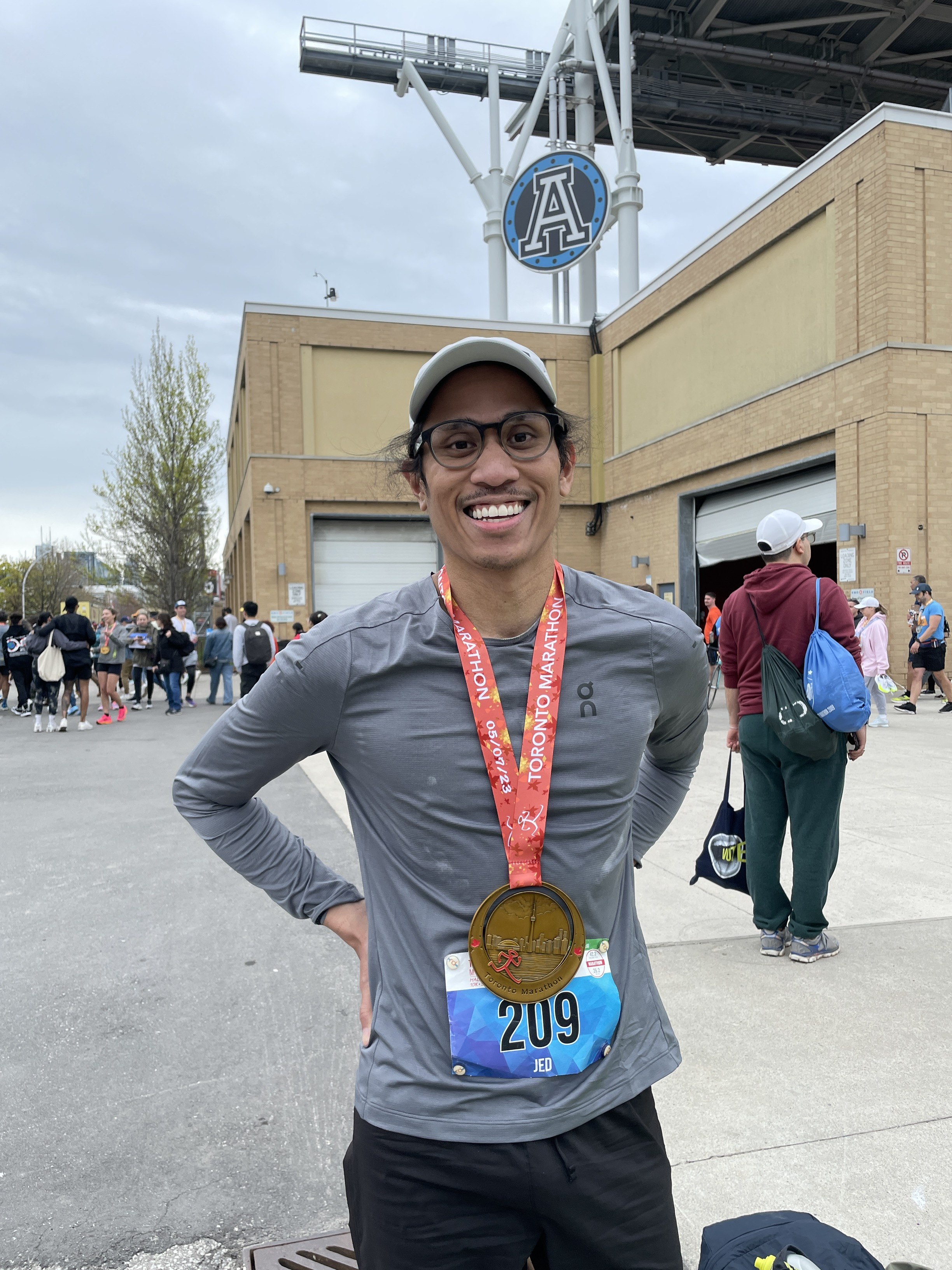 Educatoin Commons' Jed Dela Cruz, all smiles and wearing his medal after completing the Toronto Marathon in May 2023.