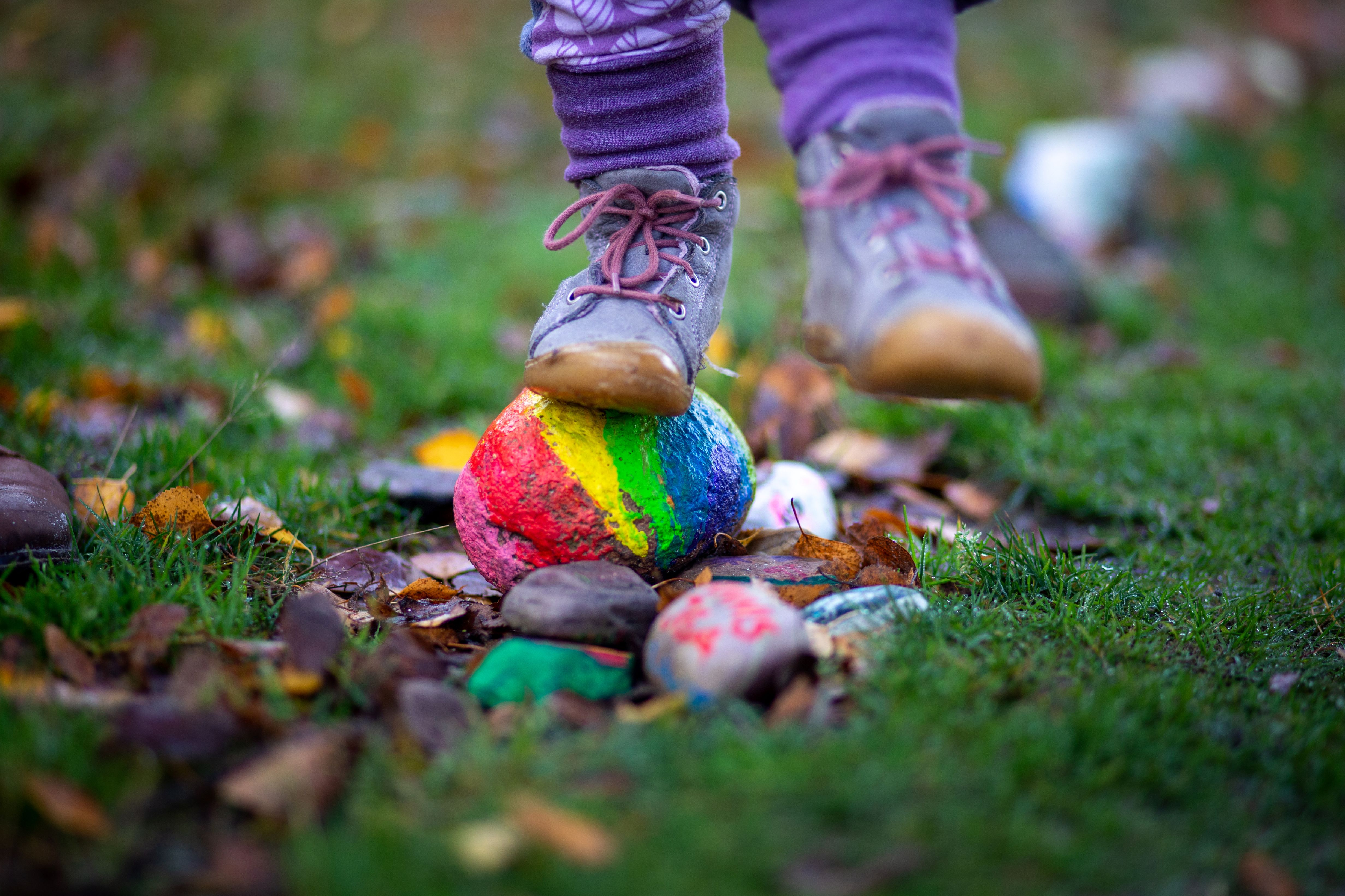 Child's feet, standing on rainbow rock