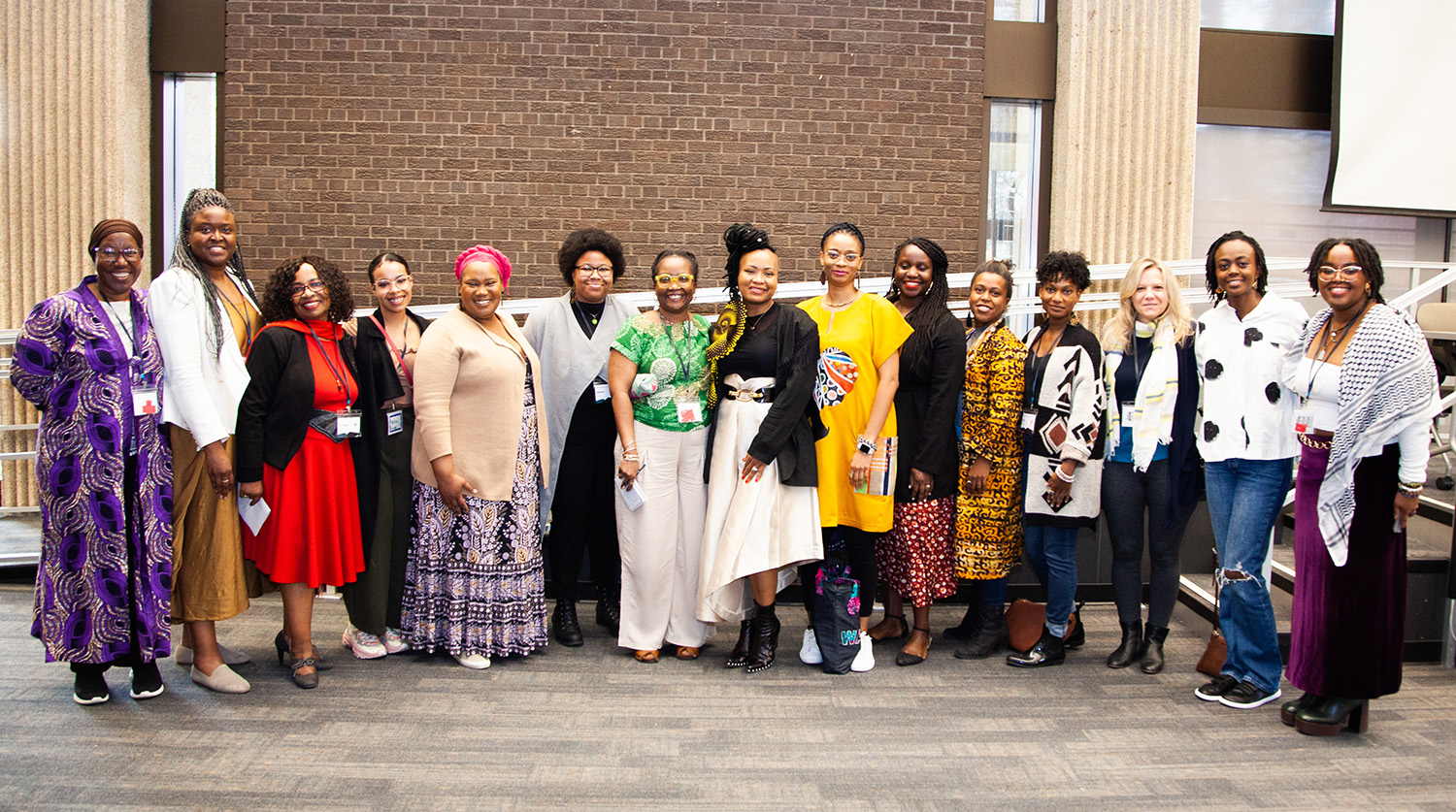 15 attendees of the Black/African Feminisms Conference are smiling for the camera