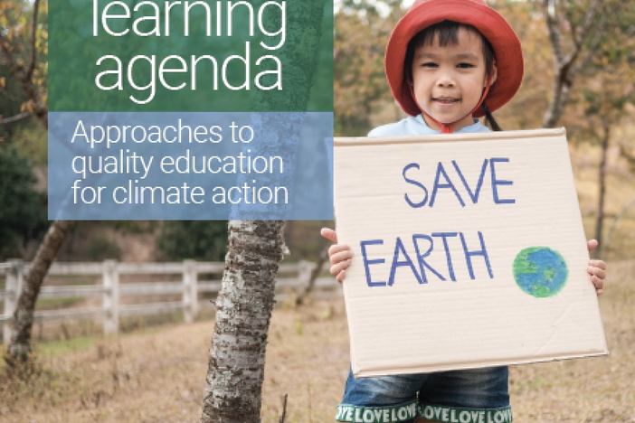 Child holding sign that reads save earth