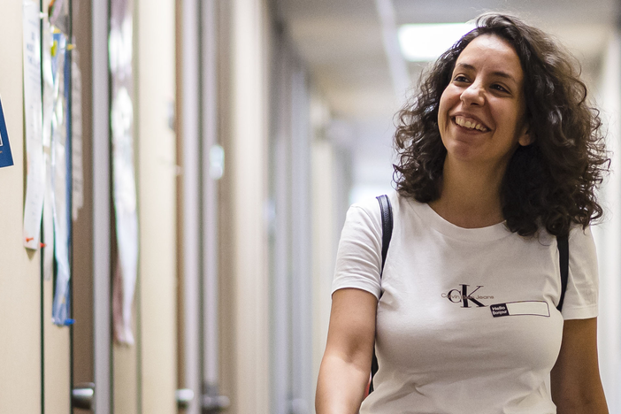 A student walking through an OISE hallway.