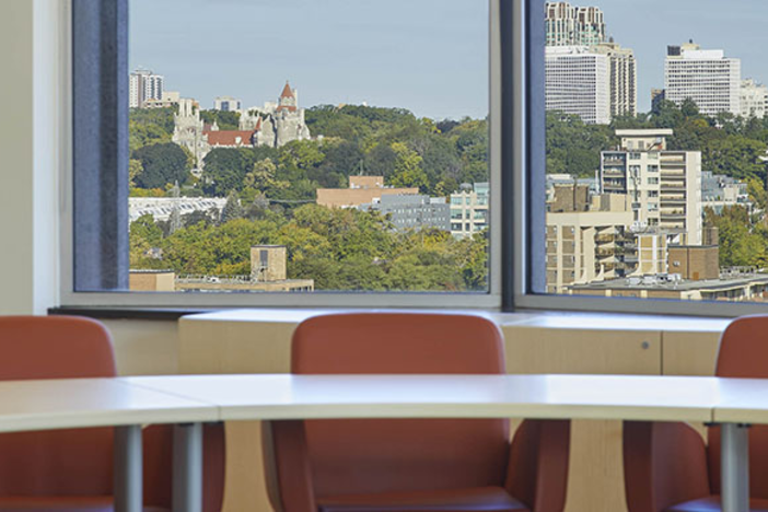 A classroom with a nice view of Toronto and orange chairs.