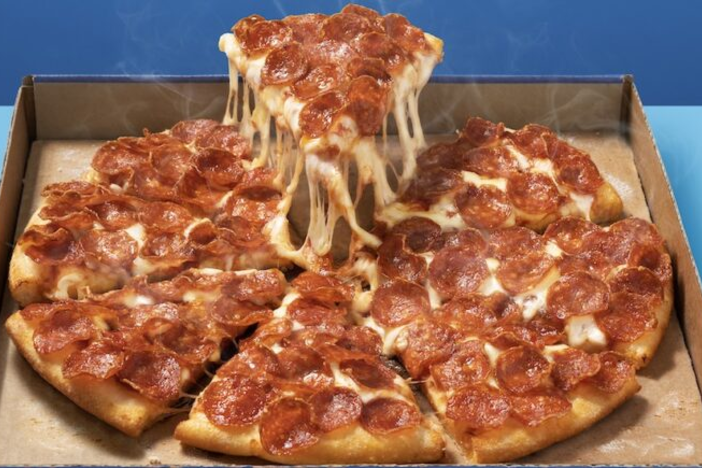 Pepperoni pizza in a box on a blue table