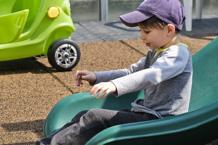 A child sliding down a slide in a playground.