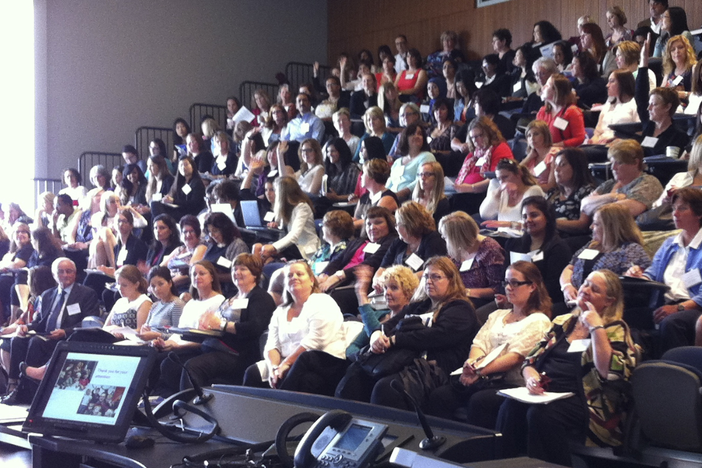 An individual presenting to a room full of individuals at the 11th Annual Summer Institute on Early Childhood Development.