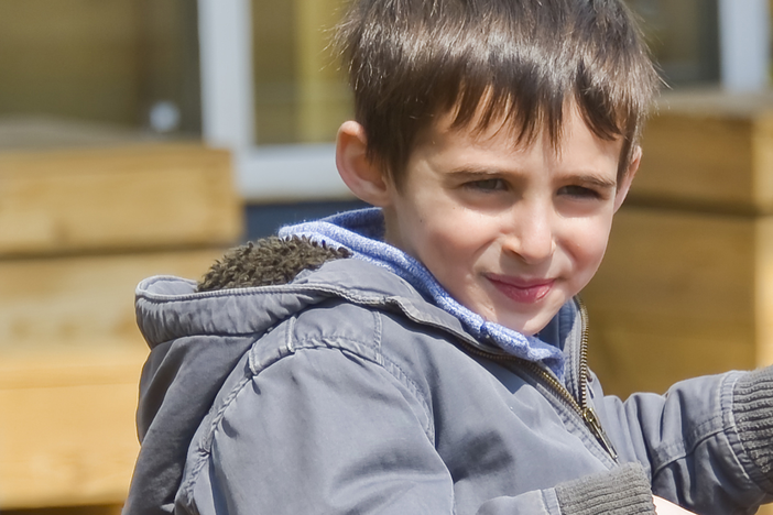 A child smirking in a playground playset.