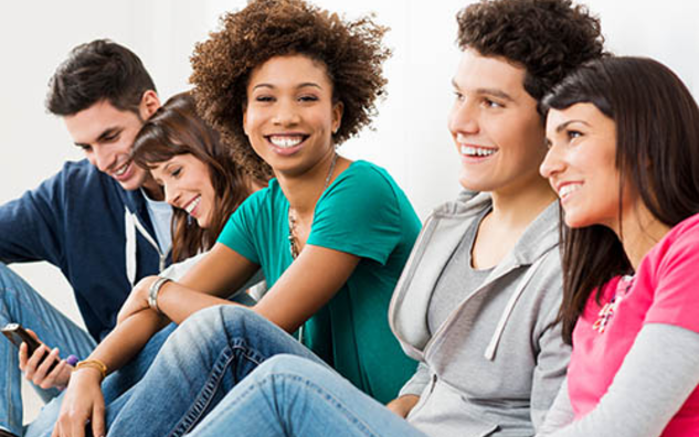 A group of people sitting and smiling. 