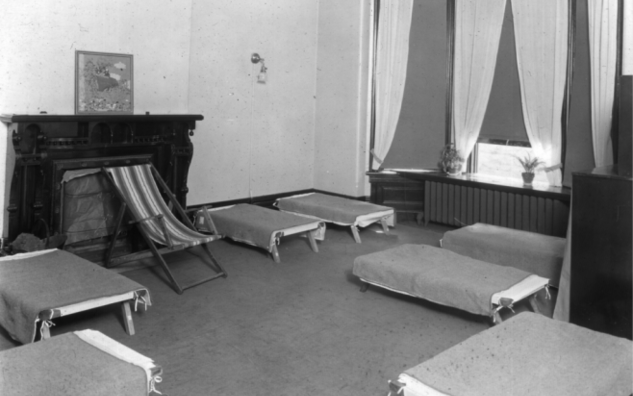 A dated photo of cots in a room at JICS.