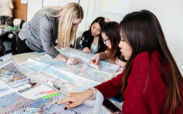 A group of four graduate students working at a table.