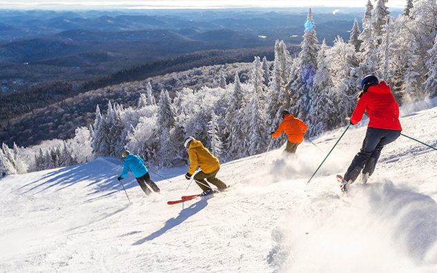 Four people skiing down a hill. 