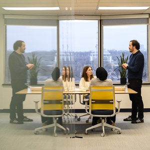 Professor Jeffrey Ansloos is talking with two graduate students inside the new Critical Health and Social Action Lab.