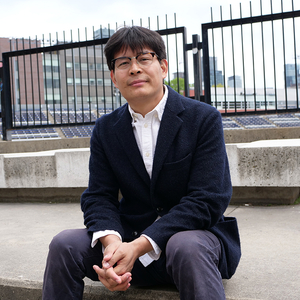 Nan La, a tibetan student presenting as a man, is sitting in front varsity stadium at the University of Toronto