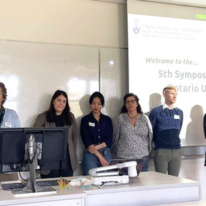 The symposium organizing committee standing at the front of a classroom