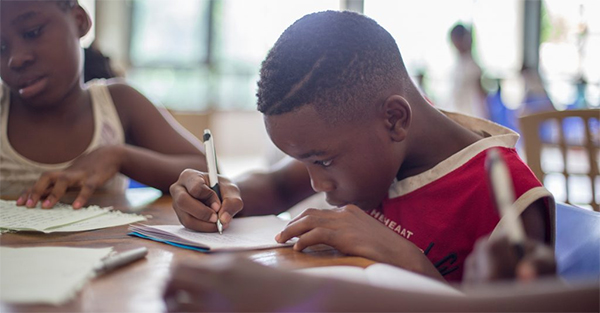 A child writing on a piece of paper.