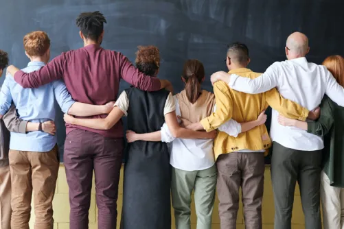 A group of people embracing and turned around.