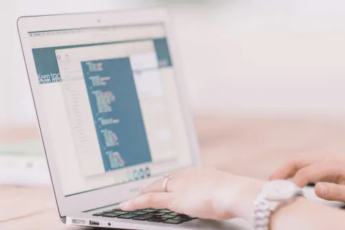 A person typing on a laptop keyboard.