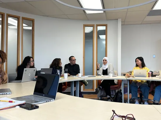 Five people sitting at table having a discussion