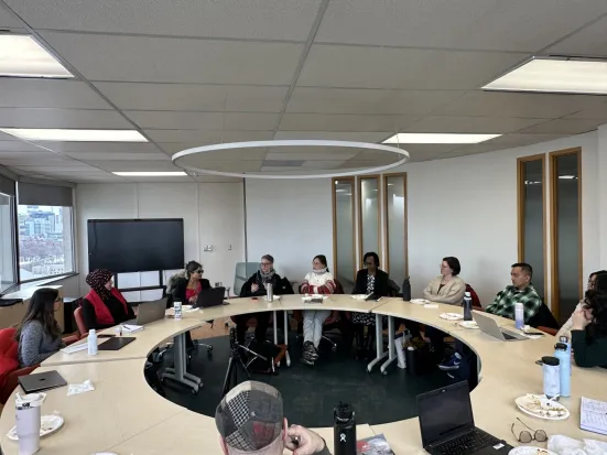 A group of people sitting around a round table.