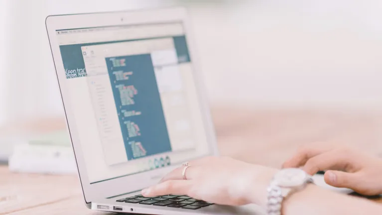 A person typing on a laptop keyboard.